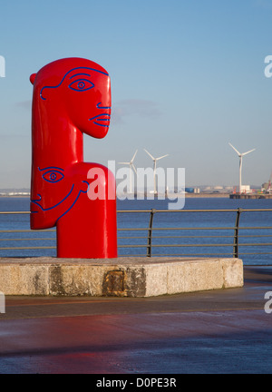 Jon Buck Skulptur "Ship to Shore" mit Gesichtern suchen in entgegengesetzte Richtungen an Portishead Marina mit Avonmouth Windpark Stockfoto