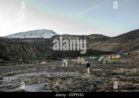 KILIMANDSCHARO, Tansania – Zelte im Moir Hut Camp (13.660 m) auf der Lemosho Route des Kilimandscharo. Der schneebedeckte Berggipfel befindet sich in der Entfernung links. Stockfoto