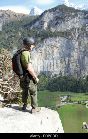 Base-Jumper ist bereit, von einer Klippe hinunter ins Tal an einem schönen Nachmittag tauchen. Er lächelt sogar er ist nervös. Stockfoto