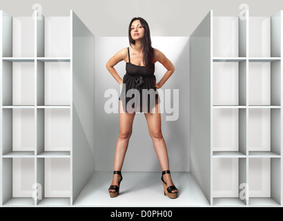 schöne Frau passt auf ein schwarzes Kleid in Umkleidekabine Stockfoto