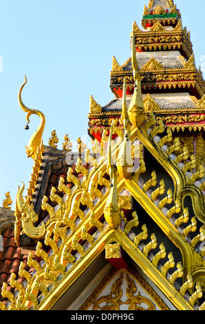 Wat Sisaket Verziertes goldenes siamesisches Dach Vientiane Laos | VIENTIANE, Laos — Vergoldete Chofah-Aufsätze krönen die mehrstufige Dachlinie des Sim bei Wat Sisaket, das für König Anouvong etwa zwischen 1818 und 1824 erbaut wurde. Sein siamesischer Dachstil aus Bangkok, ungewöhnlich für einen laotischen Königstempel, ist das Detail, das Gelehrte dafür verantwortlich machen, dass das Gebäude verschont blieb, als siamesische Truppen Vientiane 1827–1828 zerstörten, und es somit zum ältesten erhaltenen Tempel der Stadt machte. Stockfoto