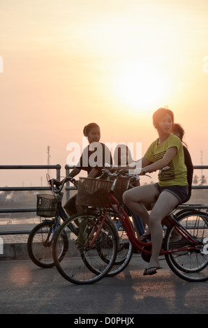 VIENTIANE, Laos - Vientiane einheimischen Fahrt ihre Fahrräder in den späten Nachmittag auf der breiten Promenade entlang der Ufer des Mekong. Stockfoto