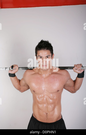 Sportlicher junger Mann dabei Training mit Gewichten Stockfoto