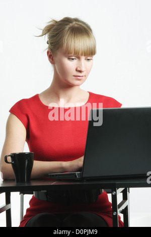 Geschäftsfrau in rot schreiben auf laptop Stockfoto