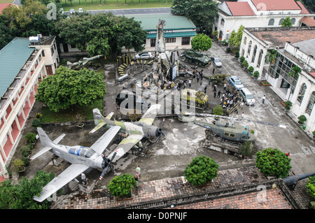 HANOI, Vietnam – Ein Blick aus der Vogelperspektive von der Aussichtsplattform des Hanoi Flag Tower zeigt eine Reihe gefangener und verlassener US-Militärausrüstung, die im Innenhof des Vietnam Military History Museums ausgestellt ist. Der Außenausstellungsraum am Fuß des 33 Meter hohen Turms zeigt verschiedene Fahrzeuge und Ausrüstungen aus der Vietnamkriegszeit. Diese erhöhte Perspektive bietet einen umfassenden Blick auf die Sammlung militärischer Artefakte des Museums. Stockfoto