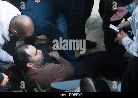 Jerusalem, Israel. 29. November 2012. Wie Polizei erfolgreich eine palästinensische Fahne aus den Händen von Demonstranten, die verhindern, dass sie brennen es reißen, läuft ein Mann in der Menge mit einer zusätzlichen Flagge. Polizei Detektive lösen ihn auf den Boden und machen eine Verhaftung. Jerusalem, Israel. 29. November 2012.  MKs Michael Ben-Ari und Aryeh Eldad, der extremen Rechten Otzma Leyisrael Partei, Blei-Aktivisten in einem palästinensischen Flagge brennenden versuchen auf UN-Gebäude in Jerusalem demonstrieren gegen palästinensische Staatlichkeit Gebot bei der UN-Generalversammlung in New York. Stockfoto