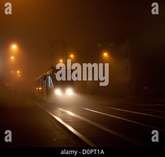 Straßenbahn auf Stadtstraße im Nebel Stockfoto