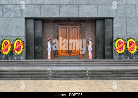HANOI, Vietnam - Zwei Wachen in voller Uniform stand Wache am Eingang des Ho Chin Minh Mausoleum. Ein großes Denkmal in der Innenstadt von Hanoi von Ba Dinh Square, das Ho Chi Minh Mausoleum umgeben die Häuser der einbalsamierte Körper des ehemaligen vietnamesischen Leader und Gründungspräsident Ho Chi Minh. Stockfoto