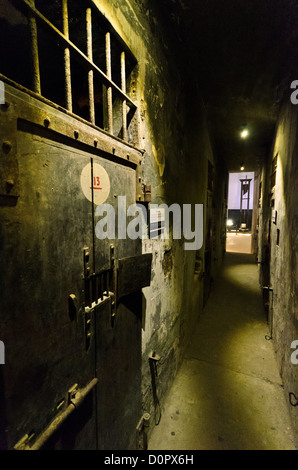 HANOI, Vietnam — Blick auf den Korridor entlang der Todeszelle, in dem die zur Hinrichtung bestimmten Gefangenen in Isolation gehalten wurden. Links befindet sich eine der verstärkten Türen der Zellen. In der Ferne, den Korridor hinunter, befindet sich eine der Guillotinen, die die französische Kolonialregierung für Hinrichtungen benutzte. Hoa Lo Prison, auch sarkastisch bekannt als Hanoi Hilton während des Vietnamkriegs, war ursprünglich ein französisches Kolonialgefängnis für politische Gefangene und dann ein nordvietnamesisches Gefängnis für Kriegsgefangene. Es ist besonders berühmt für sein Gefängnis für amerikanische Piloten, die während des Vietnamkriegs abgeschossen wurden. Stockfoto