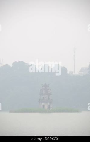 HANOI, Vietnam – der Schildkrötenturm (Thap Rua) auf einer kleinen Insel mitten im Hoan Kiem See im Herzen von Hanoi wird teilweise von einem dicken Morgennebel verdeckt. Kopierraum oben im Rahmen. Stockfoto