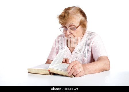 alte Frau in Gläsern liest das Buch Stockfoto