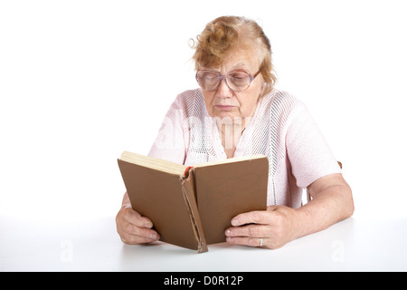 alte Frau in Gläsern liest das Buch Stockfoto