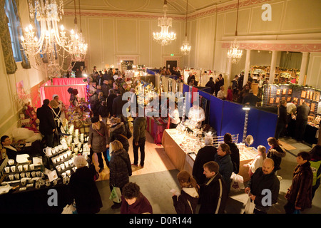 Menschen beim Einkaufen an Ständen in das Innere des Athenaeum, Bury St Edmunds, Suffolk UK Stockfoto