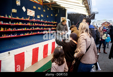 Festplatz Spiel Kind Gewehrschießen mit Familie, Bury St Edmunds Christmas Market fair, Suffolk UK Stockfoto