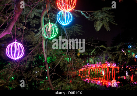 HANOI, Vietnam – Hoan Kiem See mit Lichtern, mit der Huc Bridge (Morgensonnenbrücke) im Hintergrund rechts. Die rot gestrichene Holzbrücke verbindet das Nordufer des Sees mit der Jade Island und dem Tempel des Jade Mountain (Ngoc Son Temple). Stockfoto