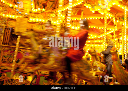 Frau auf einem Pferd auf einem Karussell Messegelände fahren, Weihnachtsmarkt zum Bury St Edmunds, Suffolk UK Stockfoto