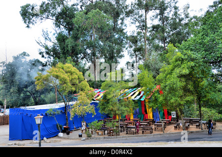 Cottage-Terrasse im Wald mit Holzbänken und Stoff-Zelte Stockfoto