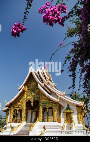 LUANG PRABANG, Laos – die kunstvolle Fassade und die steil abgewinkelte Dachlinie von Haw Pha Bang (Schlosskapelle) im Königlichen Palastmuseum in Luang Prabang, Laos. Dieses elegante Gebäude, das 1963 begonnen wurde, zeigt traditionelle laotische Architekturelemente mit seinen komplizierten Details und dem dramatischen Dach. Stockfoto