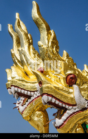 LUANG PRABANG, Laos – Goldene Naga (König Cobras) zieren die Treppe von Haw Pha Bang (Schlosskapelle) im Königlichen Palastmuseum in Luang Prabang, Laos. Die kunstvoll verzierte Kapelle in der nordöstlichen Ecke des Museumsgeländes zeigt traditionelle laotische Architektur und buddhistische Symbolik. Stockfoto