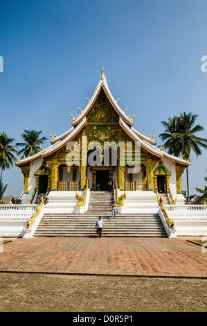 LUANG PRABANG, Laos – die kunstvolle Fassade und die steil abgewinkelte Dachlinie von Haw Pha Bang (Schlosskapelle) im Königlichen Palastmuseum in Luang Prabang, Laos. Dieses elegante Gebäude, das 1963 begonnen wurde, zeigt traditionelle laotische Architekturelemente mit seinen komplizierten Details und dem dramatischen Dach. Stockfoto