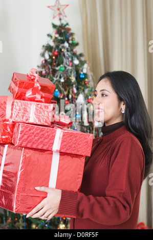 Frau hält Weihnachtsgeschenke lächelnd Stockfoto