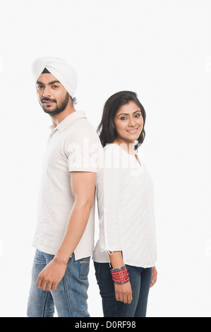 Paar stehen Rücken an Rücken und lächelnd Stockfoto