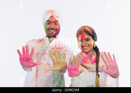 Paar zeigt ihre farbigen Hände beim Feiern Holi Stockfoto