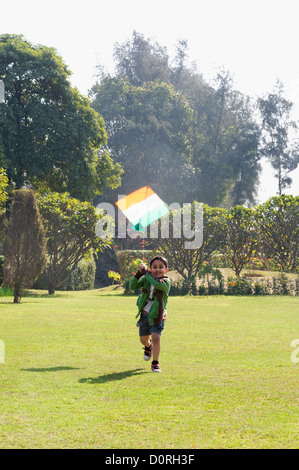 Junge spielt mit einem Drachen in einem park Stockfoto