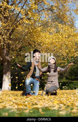 Glückliches junges Paar genießen die tanzenden Laub im Herbst Stockfoto