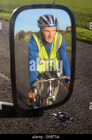 Radfahrer tragen Warnschutz Kleidung Refelected im Fahrzeug Außenspiegel auf Straße in der Nähe von Leeds United Kingdom Stockfoto