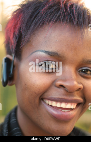 Afrikanische amerikanische Geschäftsfrau vertikale Portrait mit Bluetooth-Handy-Kopfhörer - selektiven Fokus auf linkes Auge Stockfoto