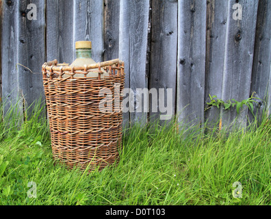 Korb mit Flasche auf grüne Kraut Stockfoto