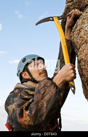 Die Kletterer Hämmer Haken in Fels Stockfoto