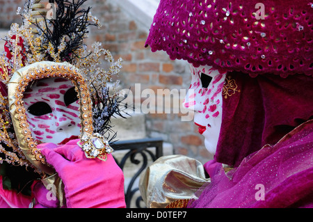 Maskierten Teilnehmer auf dem Campo Santa Maria Formosa während des Karnevals in Venedig mit ihrem Gesicht reflektiert in einem Spiegel Stockfoto