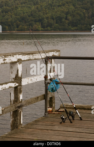 Ein paar von Angelruten am Ende des Piers auf einem schottischen See Loch 17. August 2006 Stockfoto