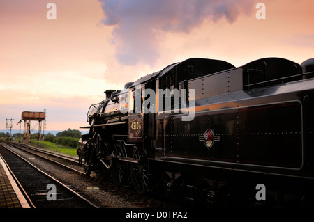 Ivatt Klasse 4 Dampflok Nr. 43106 auf der West Somerset Railway in Somerset in der Dämmerung mit einem Wasserturm im Hintergrund Stockfoto