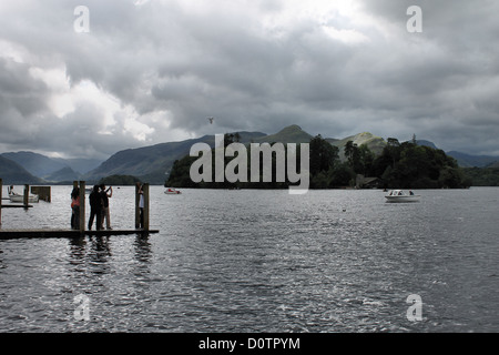 Eine Gruppe von Touristen, die am Bank Holidyay Wochenende in Derwent Water Keswick Fotos auf dem Steg machen Stockfoto