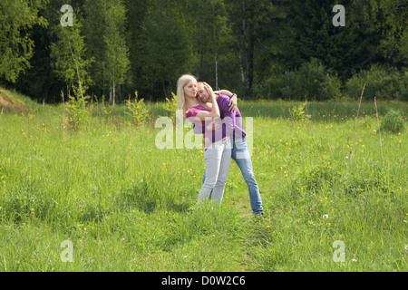 Paar auf einer Wiese im Frühjahr umarmen Stockfoto