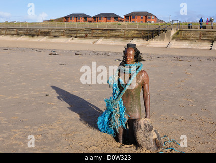 Ironman auf Crosby Strand steht Mode gekleideten Krieger im Strandgut gesammelt vom Strand entfernt Stockfoto