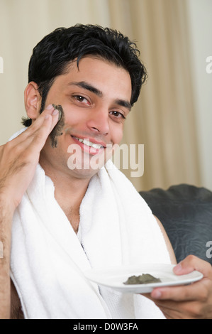 Porträt eines Mannes Moorpackung auf seinem Gesicht auftragen Stockfoto