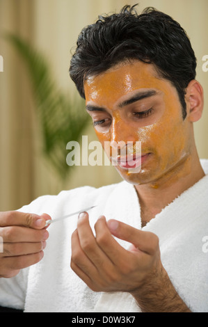 Nahaufnahme eines Mannes mit Peel-off Maske seine Nägel Feilen Stockfoto