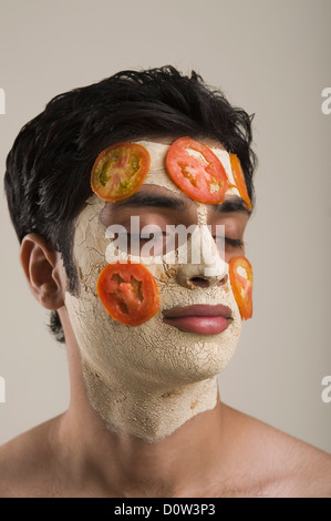 Nahaufnahme eines Mannes mit Gesichts-Maske und Tomaten Scheiben Stockfoto