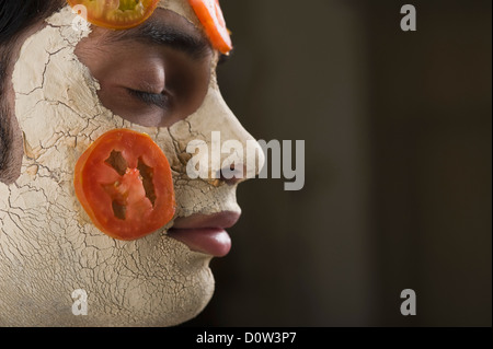 Nahaufnahme eines Mannes mit Gesichts-Maske und Tomaten Scheiben Stockfoto