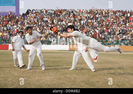 Kricket Wicketwächter und Feldspieler Versuch für einen Fang Stockfoto