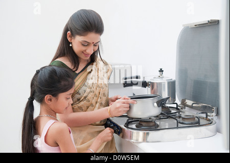 Mädchen hilft ihrer Mutter bei der Zubereitung von Speisen Stockfoto