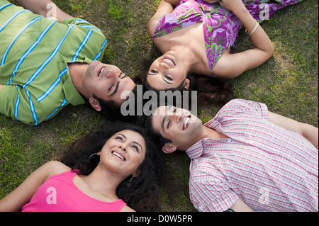 Freunde in ein Wirrwarr im Rasen liegen Stockfoto