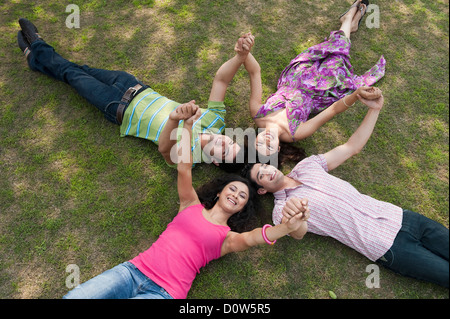 Freunde in ein Wirrwarr im Rasen liegen Stockfoto