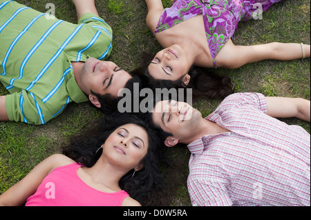 Freunde in ein Wirrwarr im Rasen liegen Stockfoto