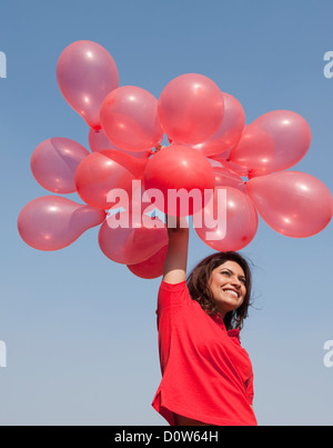 Frau hält Luftballons und genießen Stockfoto