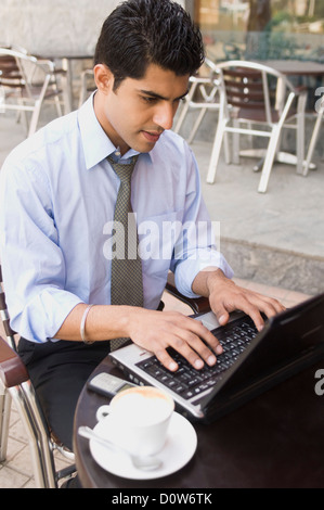Geschäftsmann mit einem Laptop in einem Straßencafé, Gurgaon, Haryana, Indien Stockfoto